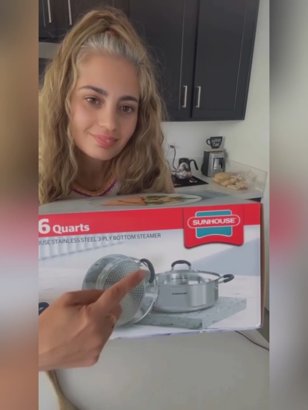 Load video: Person pointing at a Sunhouse kitchen appliance box in a kitchen setting